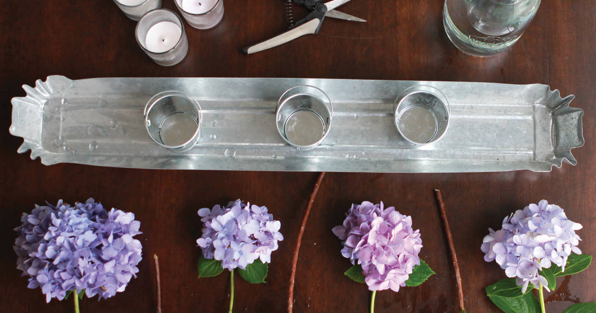 木桌，配有银桌，银烛台和剪下来的亲爱的德洛丽丝绣球花